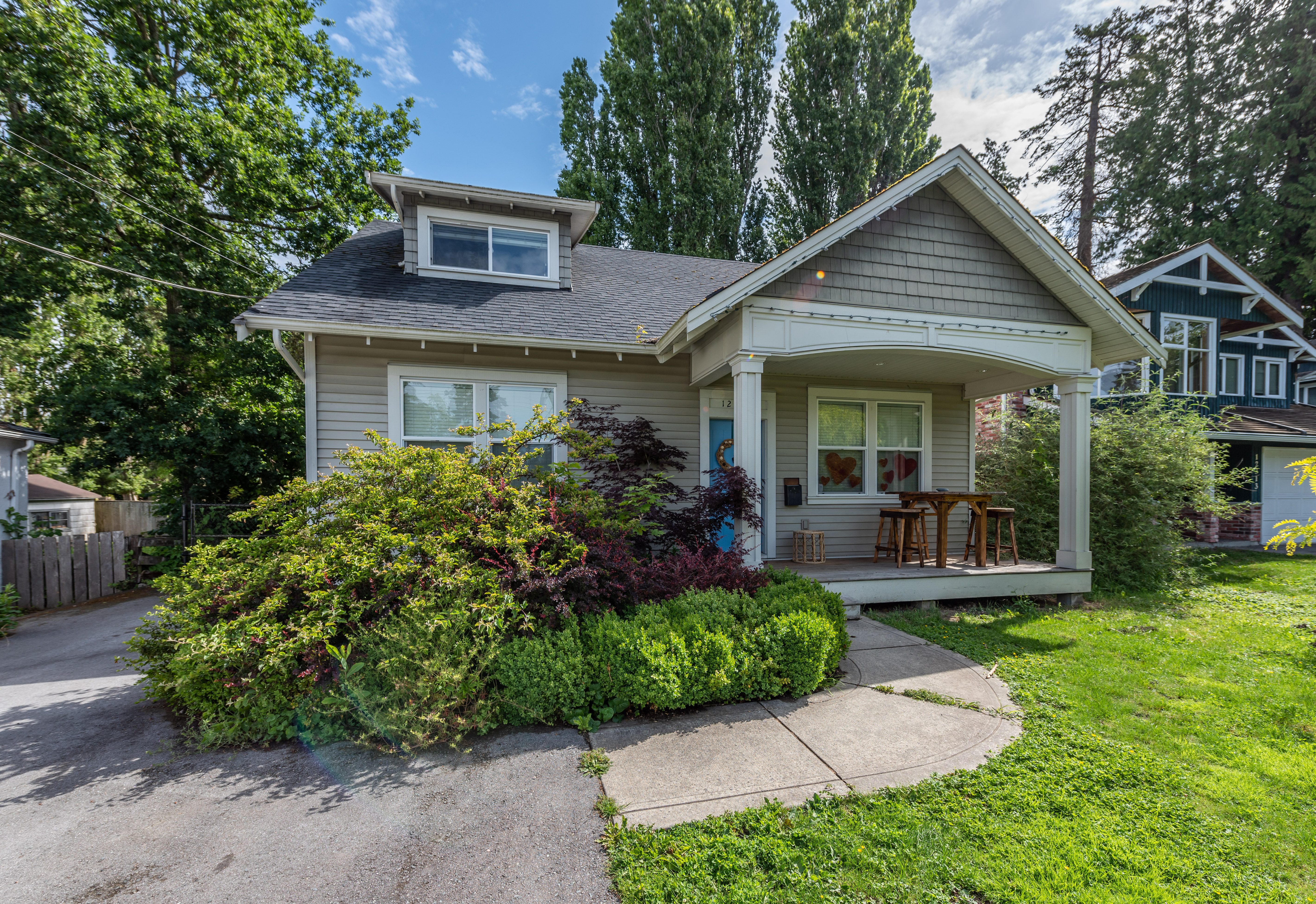 A house with a grey roof and a small porch.,A house with a grey roof and a small porch.